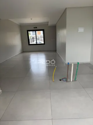 Vista de um corredor interno moderno com piso de cerâmica claro.