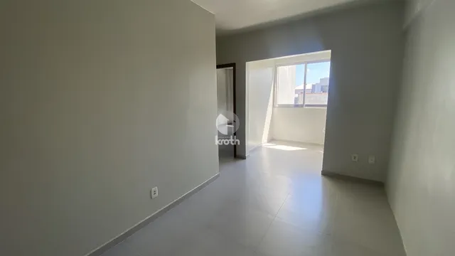 Corredor interno com piso claro e janela de luz.