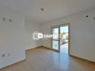 Sala de estar com piso de cerâmica e porta de vidro que dá acesso a uma área externa.