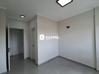 Hall de entrada com paredes brancas e piso claro.
