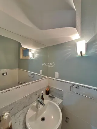 Foto de um banheiro com pia e revestimento em mármore.