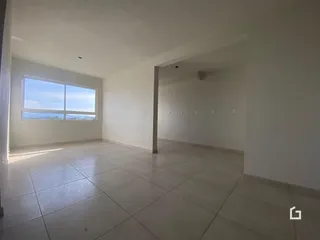 Ambiente interno amplo com piso de cerâmica e grande janela.