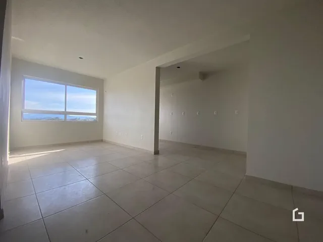 Ambiente interno amplo com piso de cerâmica e grande janela.