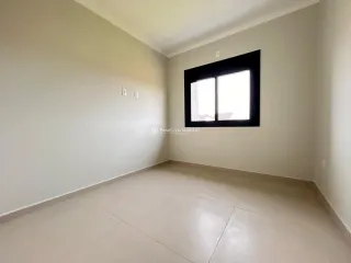Hall de corredor com piso claro e janela grande.