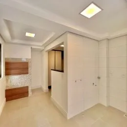 Hall de entrada com paredes brancas e armários embutidos.