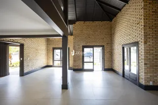 Hall de entrada com paredes de tijolo e piso de cerâmica.