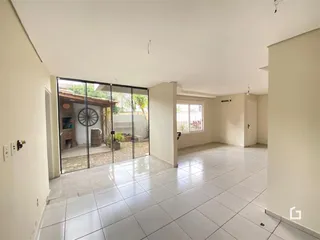 Sala de estar com porta de vidro abrindo para o quintal.
