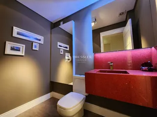 Foto de um banheiro moderno com bancada vermelha e vaso sanitário branco.