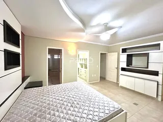 Quarto com cama grande e paredes claras em um imóvel no Brasil.