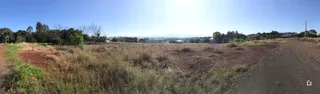 Paisagem de campo seco com vegetação rasteira e uma estrada de terra.