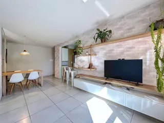 Sala de estar com parede de tijolos e móveis de madeira.