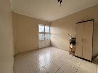 Ambiente interno de uma sala com piso de cerâmica e armário embutido.