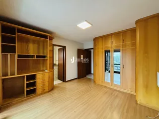 Sala de estar com armários de madeira e piso de madeira clara.