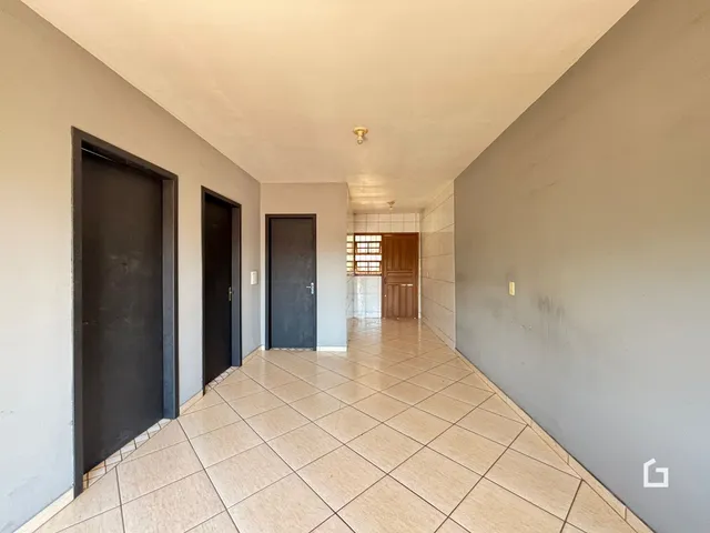 Corredor interno de uma residência com piso de cerâmica.