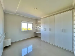 Sala de estar com paredes brancas e armários embutidos.