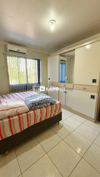 Quarto com cama e armários brancos em um imóvel.