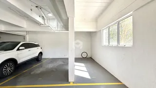 Imagem de um espaço interno com paredes brancas e uma grande janela.