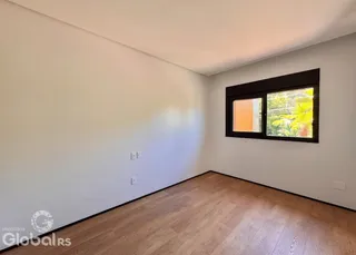 Parede branca e piso de madeira em um ambiente interno.
