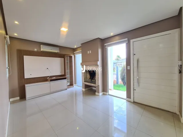 Sala de estar com piso de cerâmica clara e porta branca.