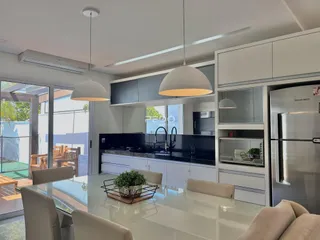Sala de jantar e cozinha moderna com acesso a uma área externa.