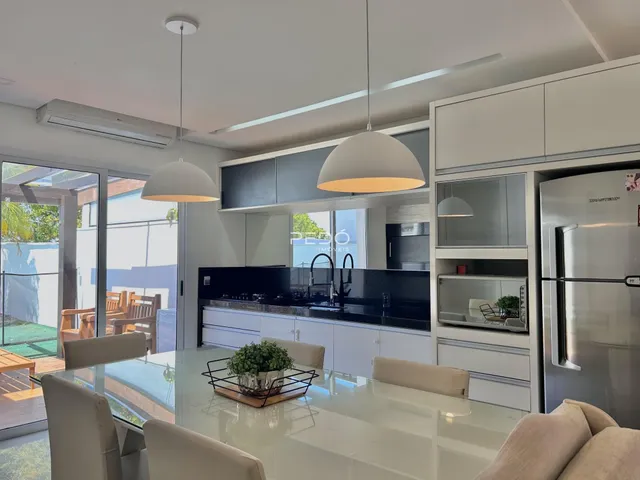 Sala de jantar e cozinha moderna com acesso a uma área externa.