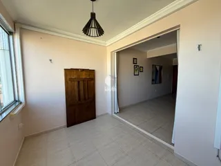 Hall com piso cerâmico claro e porta de madeira na área interna.