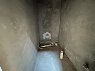 Corredor interno com paredes de concreto cru em uma residência.
