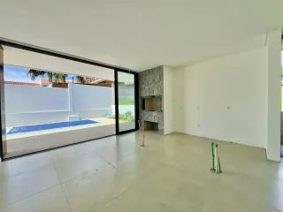 Sala de estar com vista para uma área externa com piscina.