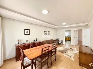 Sala de estar com mesa de jantar de madeira e sofá.
