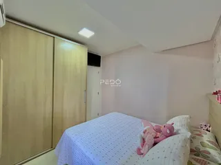 Quarto com cama e armário de madeira no interior da residência.