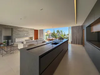 Vista de uma cozinha moderna com ilha grande e ambiente aberto.