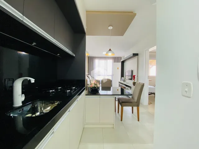 Vista da cozinha moderna com armários pretos e bancada escura.