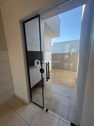 A porta de vidro mostra a transição entre o interior e o pátio externo.