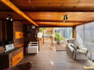 Sala de estar com piso de madeira e acesso a uma área externa com jardim.