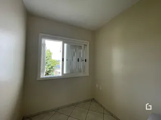 Vista interna de um cômodo com parede clara e piso de cerâmica.