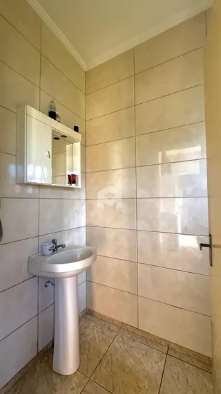 Foto de um banheiro com azulejos brancos e piso de cerâmica.