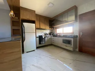 Sala de estar com armários de madeira e piso claro.