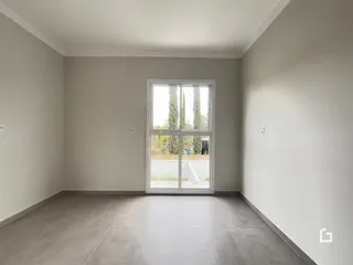 Ambiente interno com paredes brancas e piso cinza claro.
