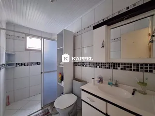 Foto de um banheiro com revestimento branco e bancada.
