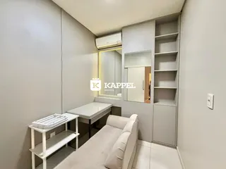Uma sala com sofá e móveis brancos em um ambiente moderno.