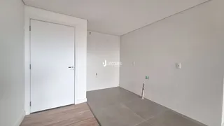 Hall de entrada com porta branca e piso cinza claro.
