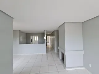 Vista de um corredor interno com piso de cerâmica claro.