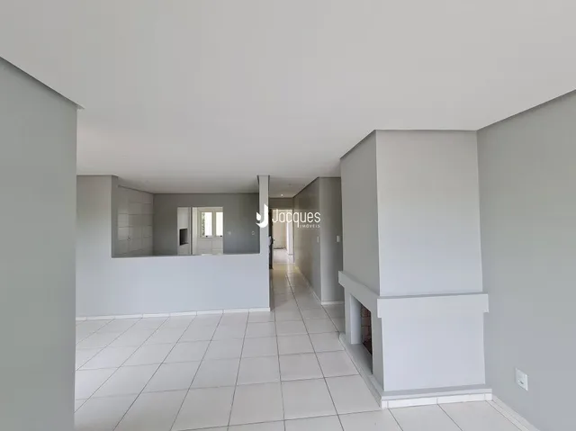 Vista de um corredor interno com piso de cerâmica claro.