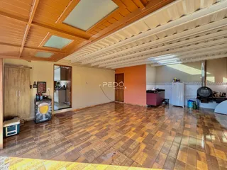 Interior de uma sala de estar com piso de cerâmica e forro de madeira.