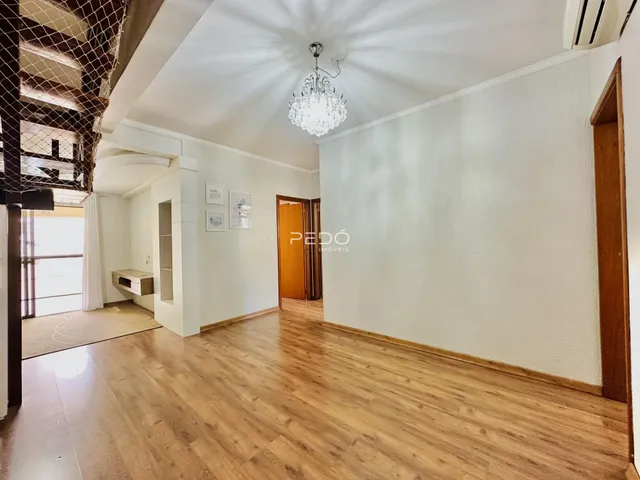 Sala de estar com piso de madeira clara e paredes brancas.
