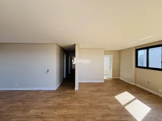 Sala de estar com piso de madeira e paredes claras.