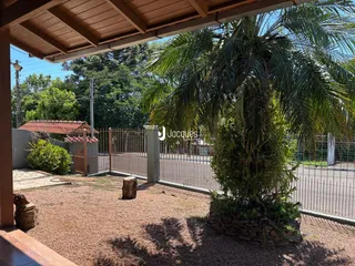 Vista externa de um quintal com cerca e vegetação.