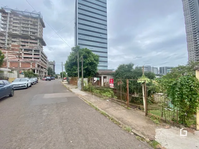Vista da rua com edifícios residenciais e um arranha-céu no fundo.