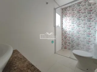 Vista parcial de um ambiente interno com banheira e porta para um quarto decorado.