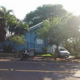 Foto da fachada de uma residência em Lajeado, Brasil, com vegetação densa ao redor.